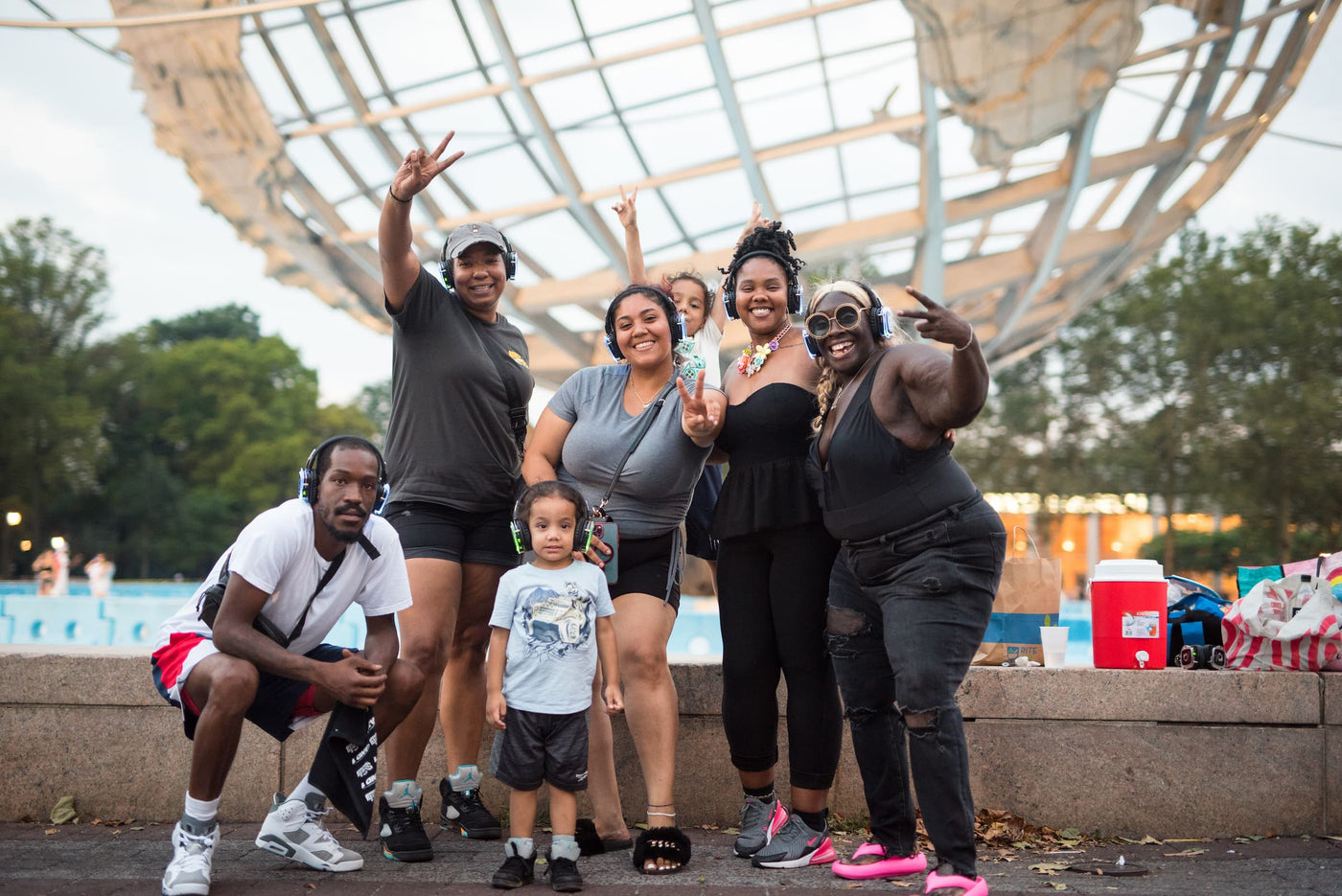 Quiet Events Silent Disco headphones for all ages.  An african american family having fun at a public park with headphones.