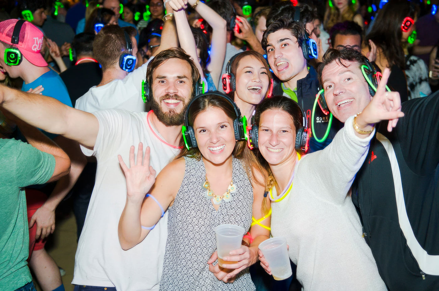 Quiet Events Silent Disco headphones for dance parties a group of people having fun and posing for a picture with headphones on