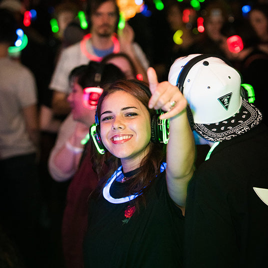 Quiet Events Silent Disco headphones for run walks. A girl giving a camera a thumbs up wearing headphones.