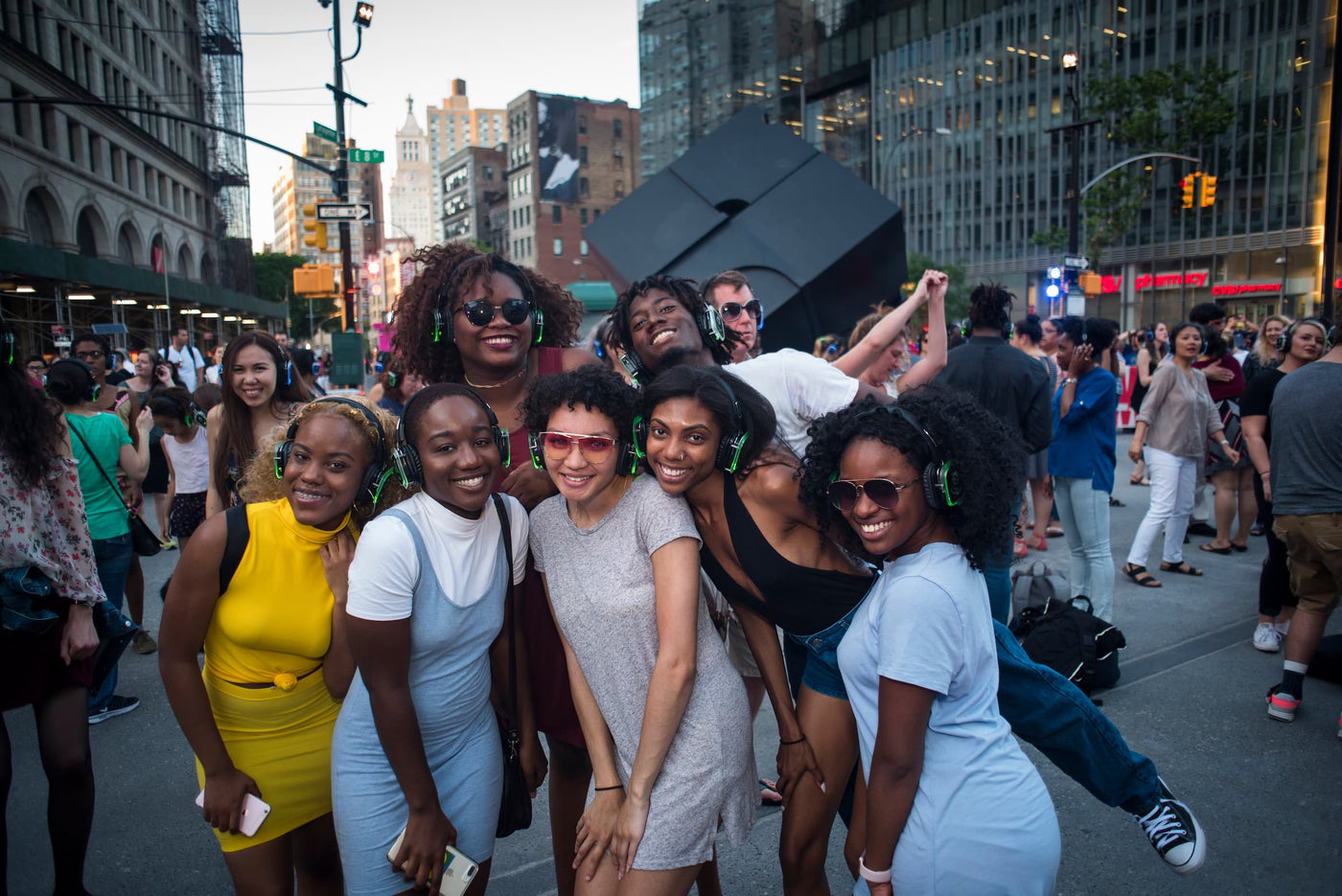 Quiet Events Silent Disco headphones for public spaces a group of girls gather together wearing headphones posing for a picture.