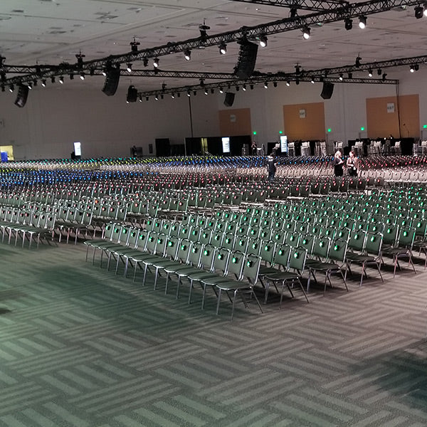 Quiet Events Silent Disco headphones for Corporate gatherings thousands of chairs with silent dsico headphones on them in a confernece hall
