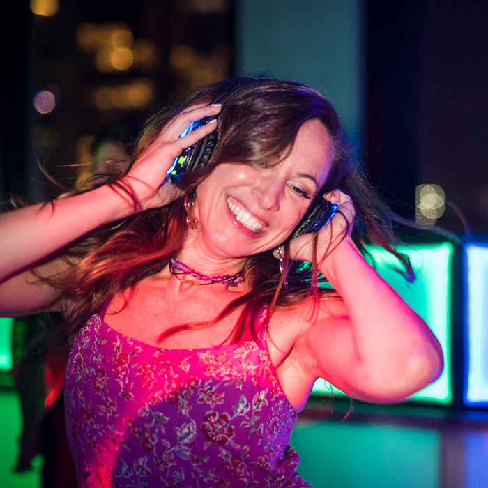 Quiet Events Silent Disco headphones for bachelorette.  A happy girl dancing and enjoying her time wearing headphones.