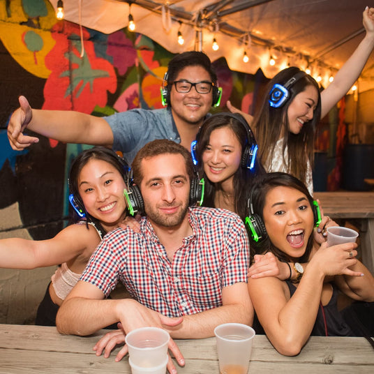 Quiet Events Silent Disco headphones for camps.  A group of young adults together having fun and wearing headphones.