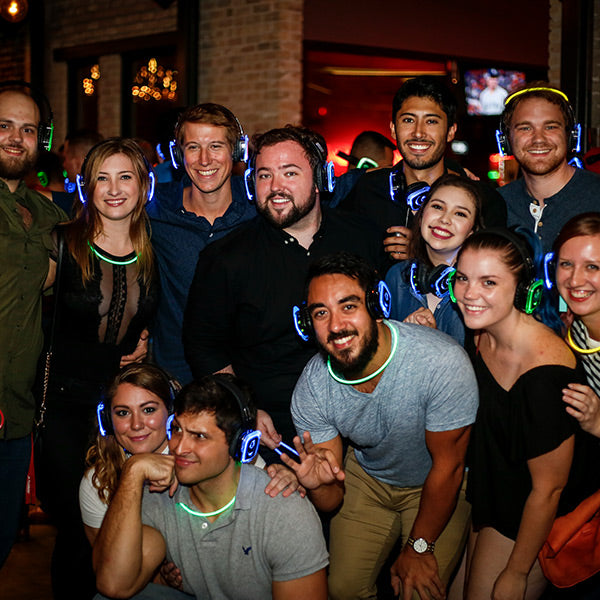 Quiet Events Silent Disco headphones for dance parties a group of people posing for a picture together wearing headphones.
