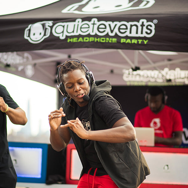 Quiet Events Silent Disco headphones for dance parties a male black man wearing headphones dancing and speaking.