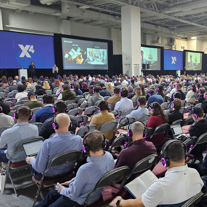 Quiet Events Silent Disco headphones for conferences, expos lots of people looking at a stage with headphones