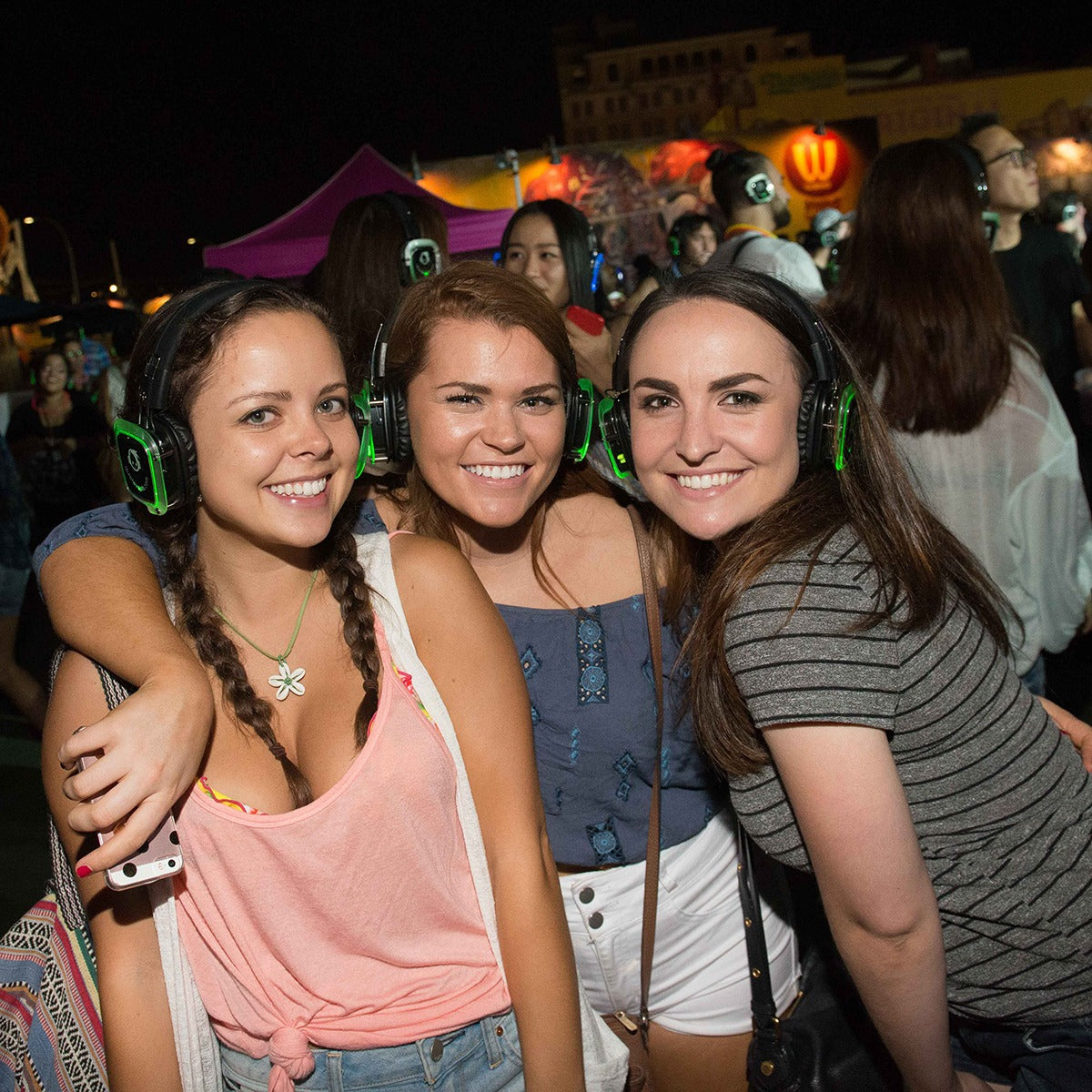 Quiet Events Silent Disco headphones for schools.  A group of young girls having fun in an outdoor setting wearing headphones.