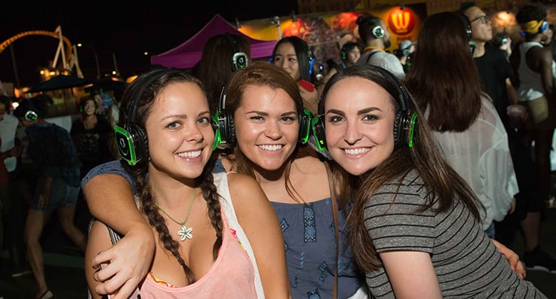 Three girls attend the festival with headphones